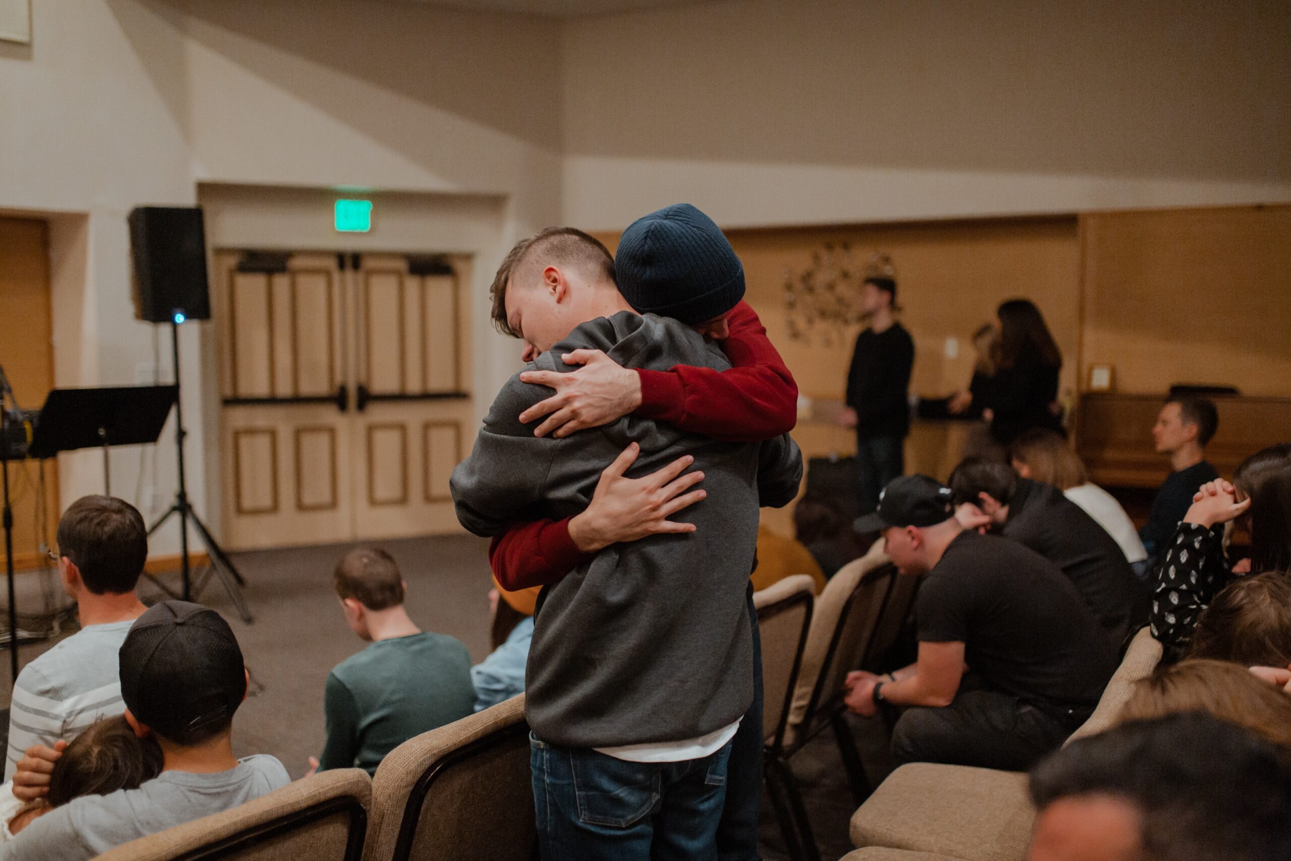 Two men hug each other during group therapy sessions